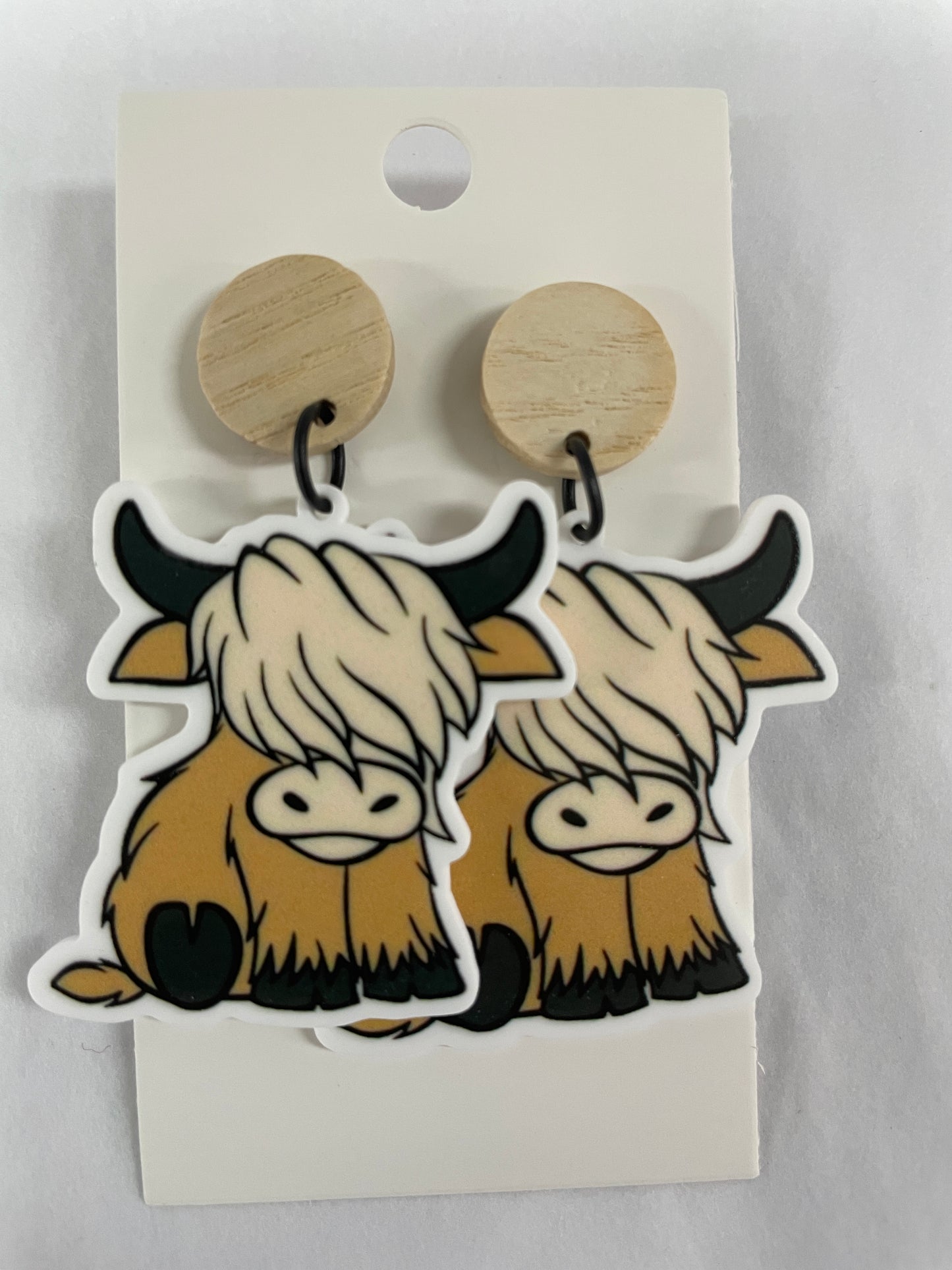 Highland Cow resin dangle earrings featuring one Highland cow on each earring with natural timber stud tops by Beldari Pottery.