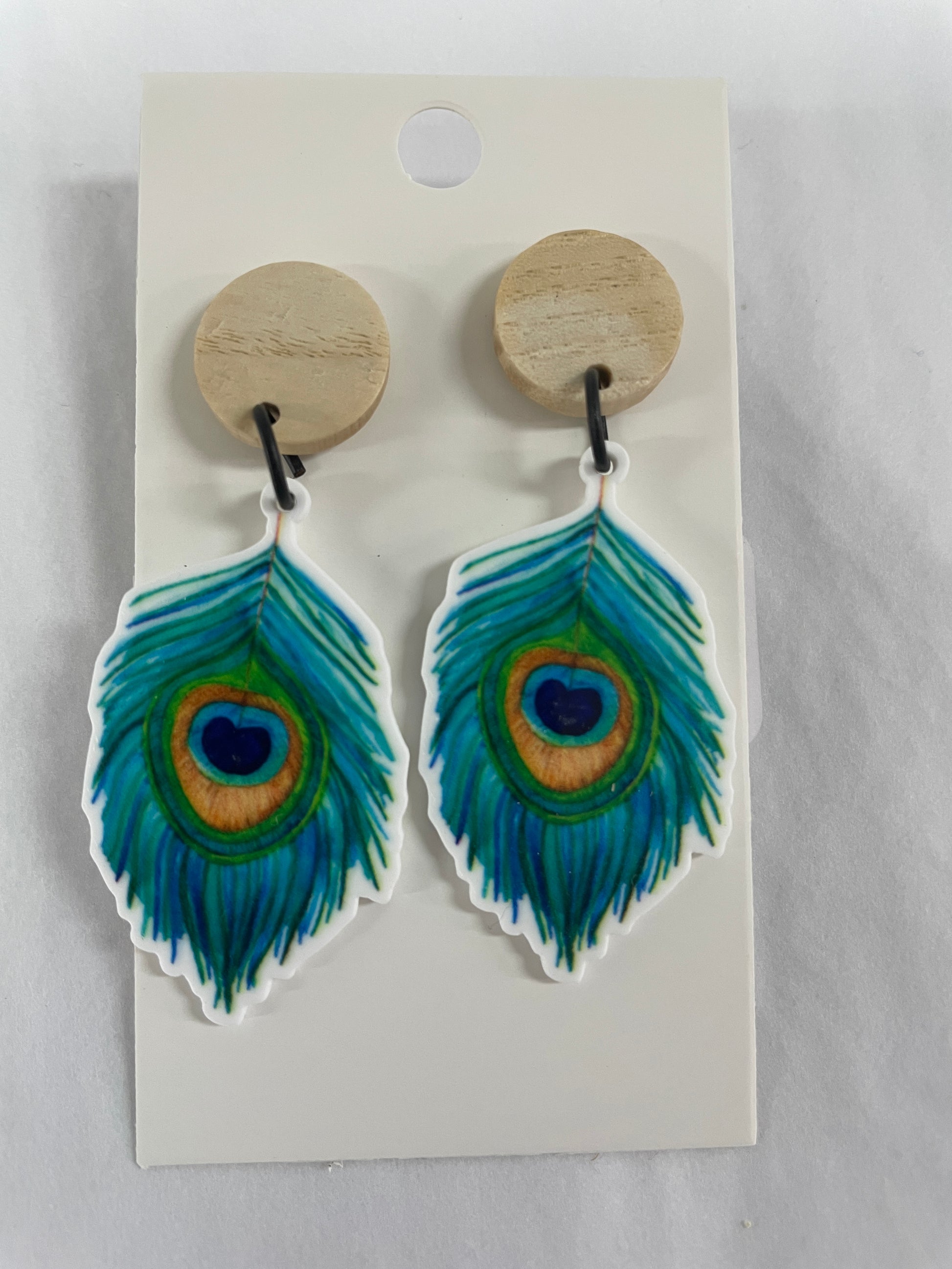 Peacock feather resin dangle earrings featuring one colourful peacock feather on each earring with natural timber stud tops by Beldari Pottery.